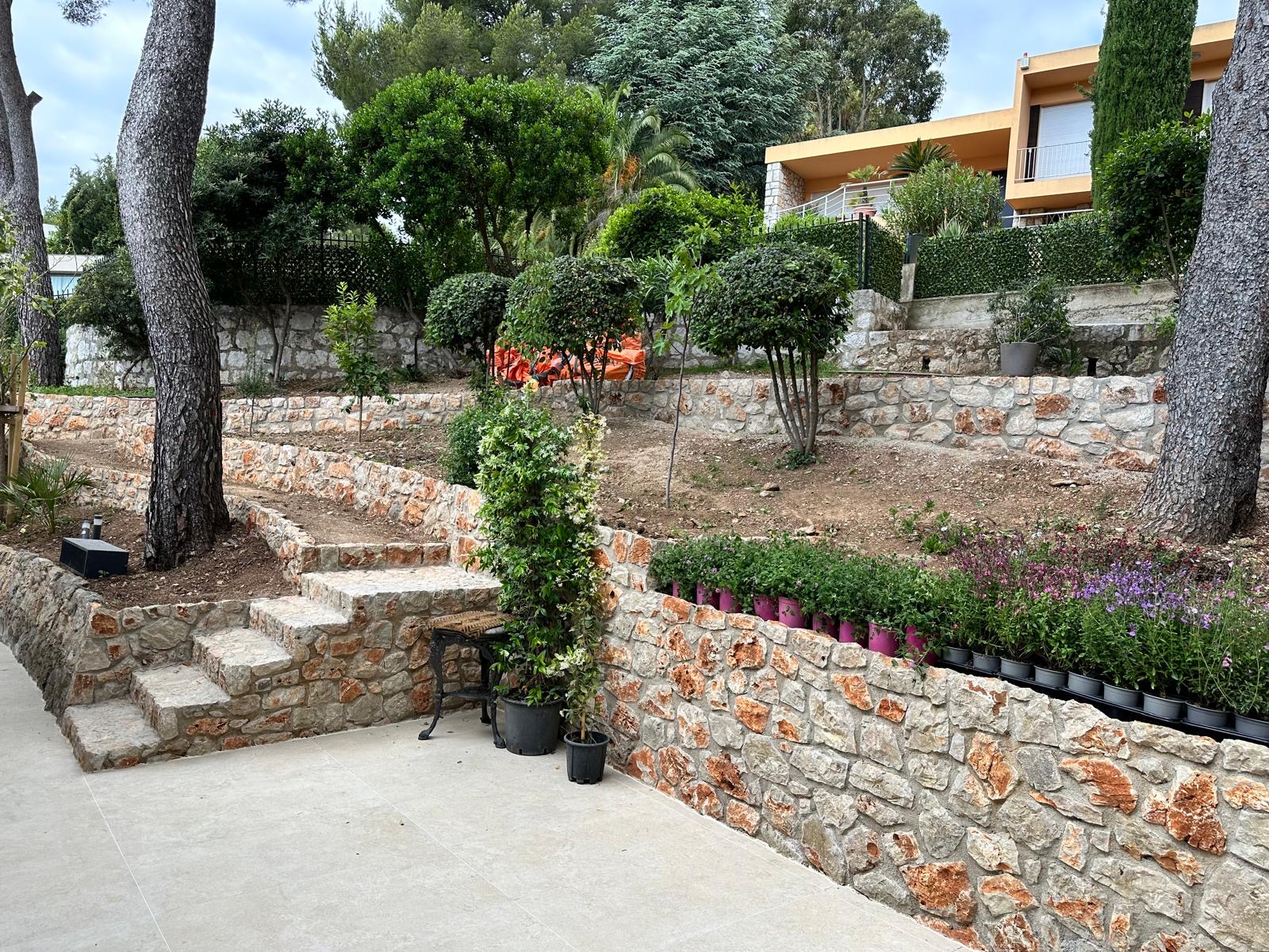 Giardino terrazzato con muri in pietra e villa