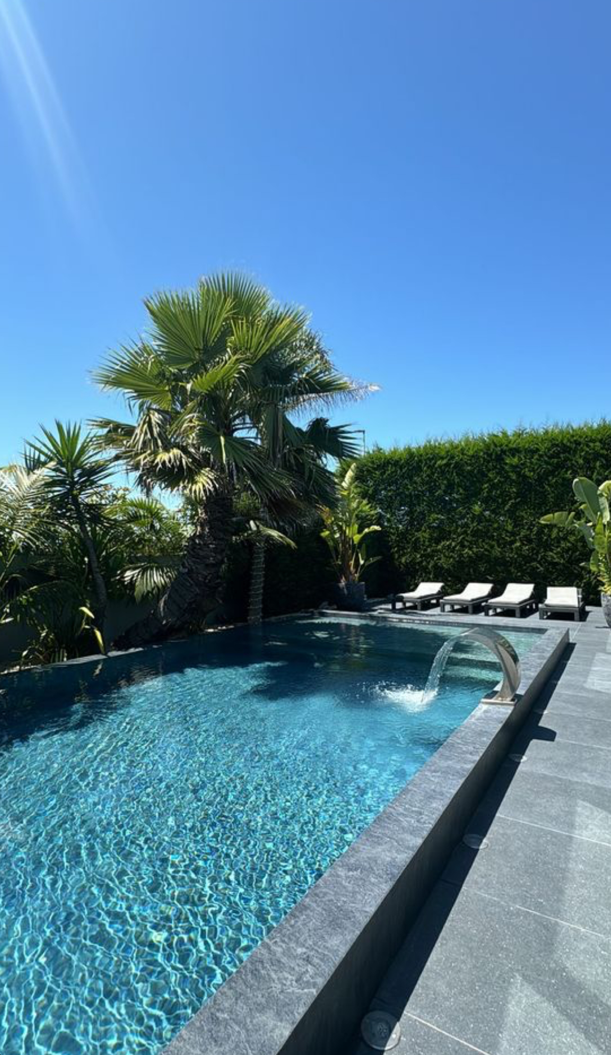 Piscina moderna con bordo vasca e area relax
